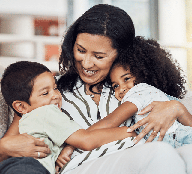 Loving mother holding her son and daughter on ther arms