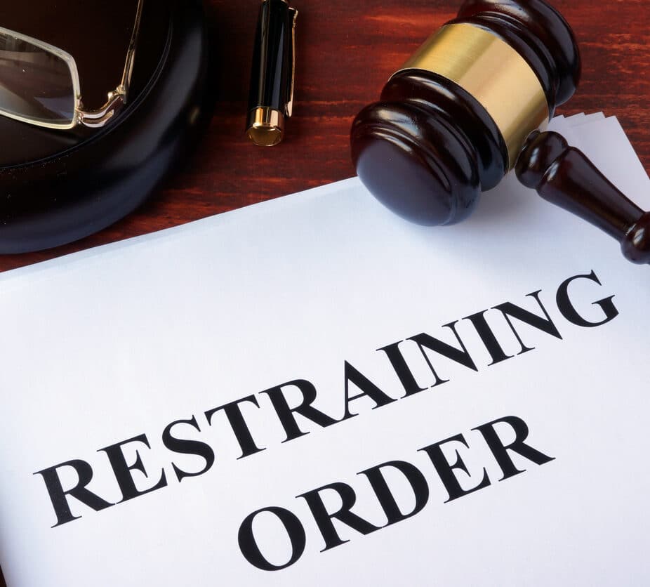 Restraining order and gavel on a table.