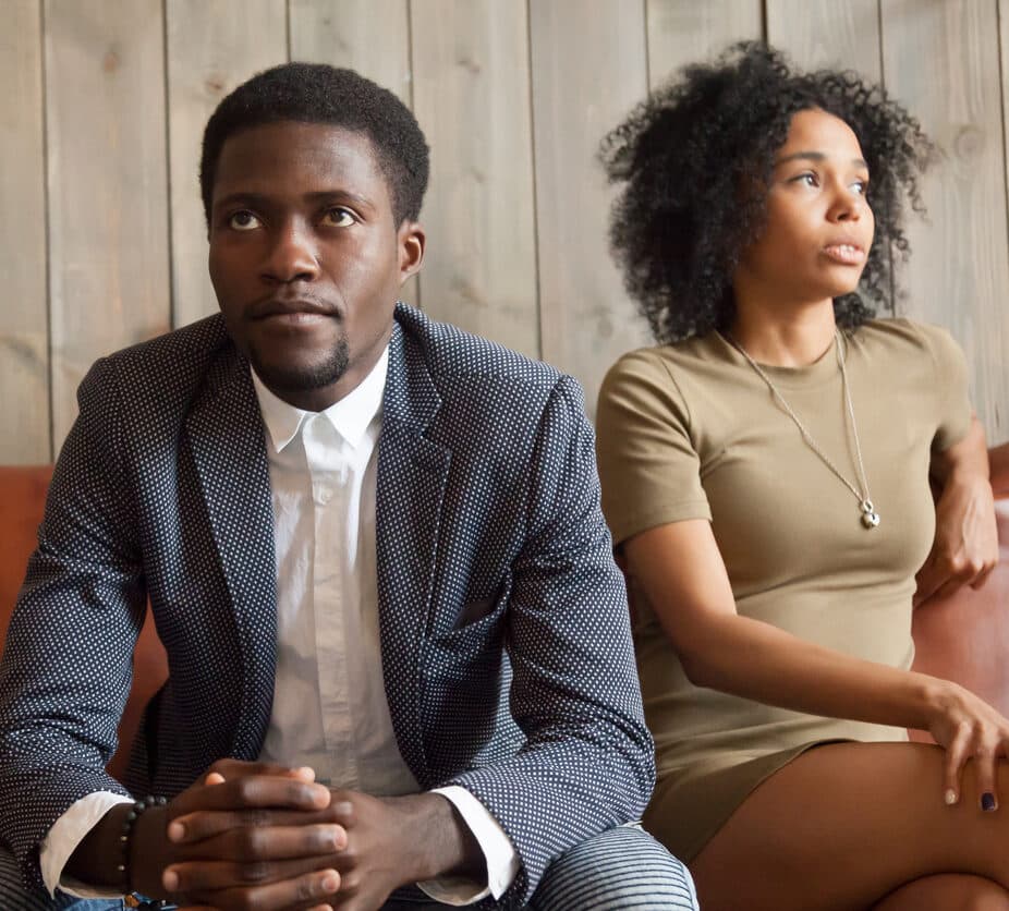 Frustrated upset couple in quarrel sitting on sofa not talking after fight